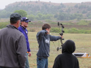 Gaige watching compound bow student